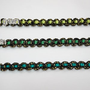 May include: Three samples of black and gold trim with different colored ribbon inserts: lime green, green, and teal.
