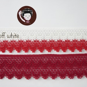 May include: Two samples of lace trim, one in red-off white and one in ruby red. Both trims have a scalloped edge and a delicate, intricate pattern.