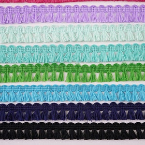 May include: A close-up of eight rows of fringe trim in various colours, including lavender, light blue, turquoise, green, blue, navy, and black. The trim is numbered 8 through 14.