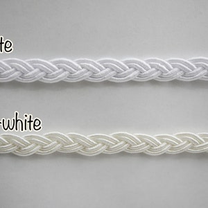 Peut inclure: Deux échantillons de cordon tressé, l'un blanc et l'autre blanc cassé. Les cordons sont tous deux de même taille et de même style.