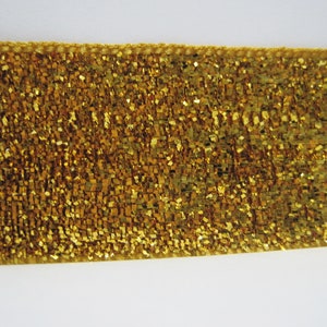 May include: Gold glitter ribbon with a textured surface.