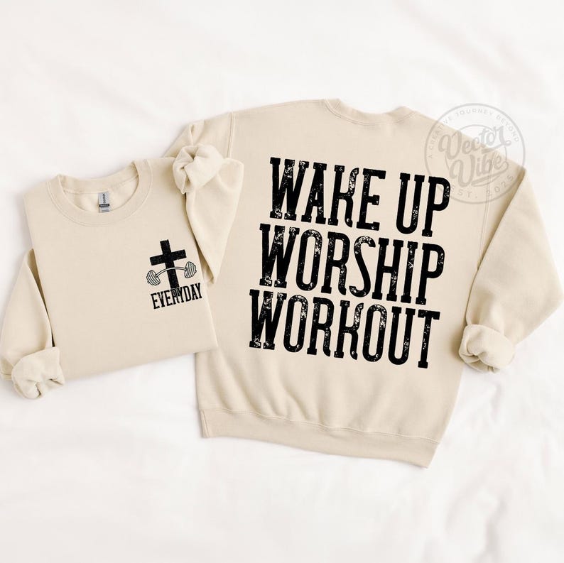 Puede incluir: Dos sudaderas beige. Una tiene un gr&aacute;fico de cruz y barra con la palabra "EVERYDAY". La otra tiene las palabras "WAKE UP WORSHIP WORKOUT" en letras negras grandes. Las sudaderas est&aacute;n sobre un fondo blanco.