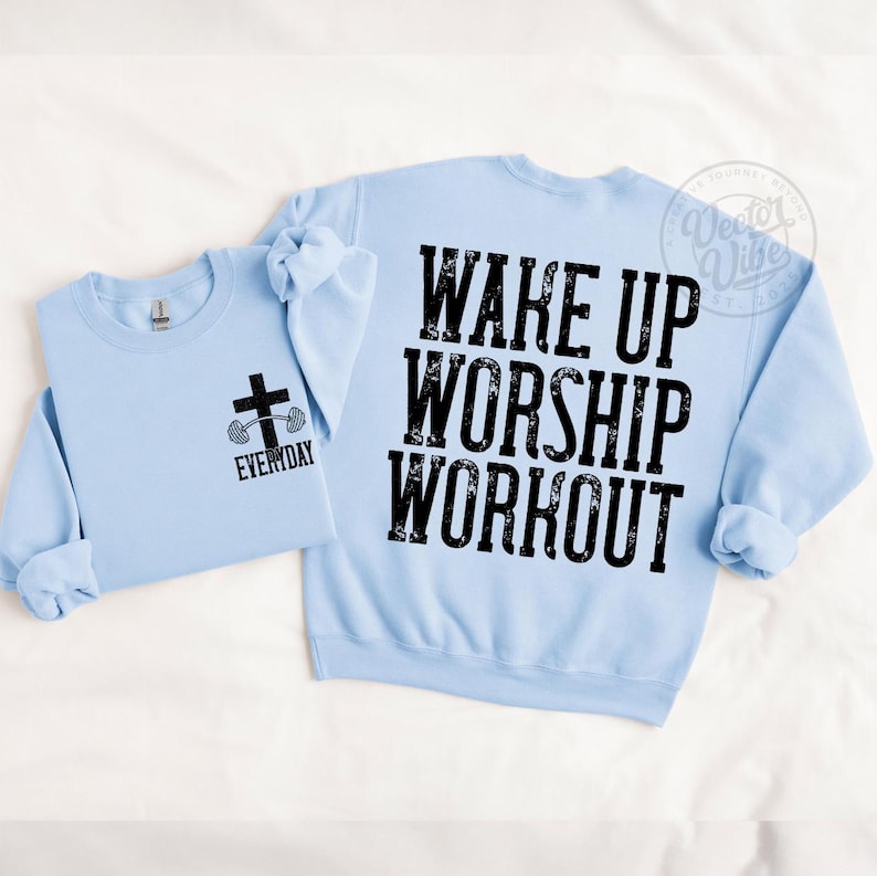 Puede incluir: Dos sudaderas de color azul claro. Una tiene un gr&aacute;fico de cruz y barra con la palabra "EVERYDAY". La otra tiene las palabras "WAKE UP WORSHIP WORKOUT" en letras negras grandes. Las sudaderas probablemente son para un tema de fitness basado en la fe.