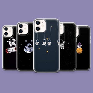 May include: Five phone cases with space-themed designs. Each case shows a different scene, including astronauts on a rocket, a moon swing, hanging from strings, floating in space, and standing on a moon. The cases have a clear border.