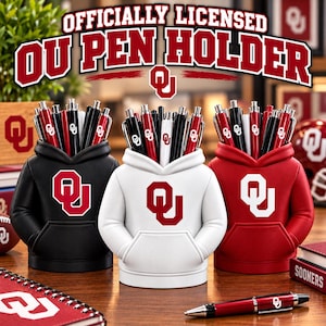 May include: Three pen holders shaped like miniature hoodies in black, white, and red, each featuring the OU logo. The holders are filled with pens and display the text "OFFICIALLY LICENSED OU PEN HOLDER" at the top of the image.