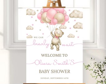 May include: A baby shower welcome sign on an easel. The sign features a teddy bear holding pink balloons, with the text "We can bearly wait" and "Welcome to Olivia Smith's Baby Shower" in pink script. The date is September 14th.
