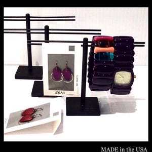 May include: Black metal jewelry display stands holding bracelets, earrings, and a watch. The stands have horizontal bars for displaying items. The image includes the text "JEWERY DISPAY STANDS" and "MADE in the USA".