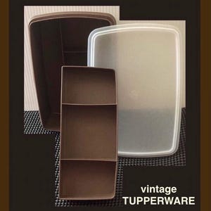 May include: A vintage Tupperware food storage container set consisting of a dark brown rectangular base, a matching dark brown three-section insert tray, and a translucent white rectangular lid. The text vintage TUPPERWARE is visible.