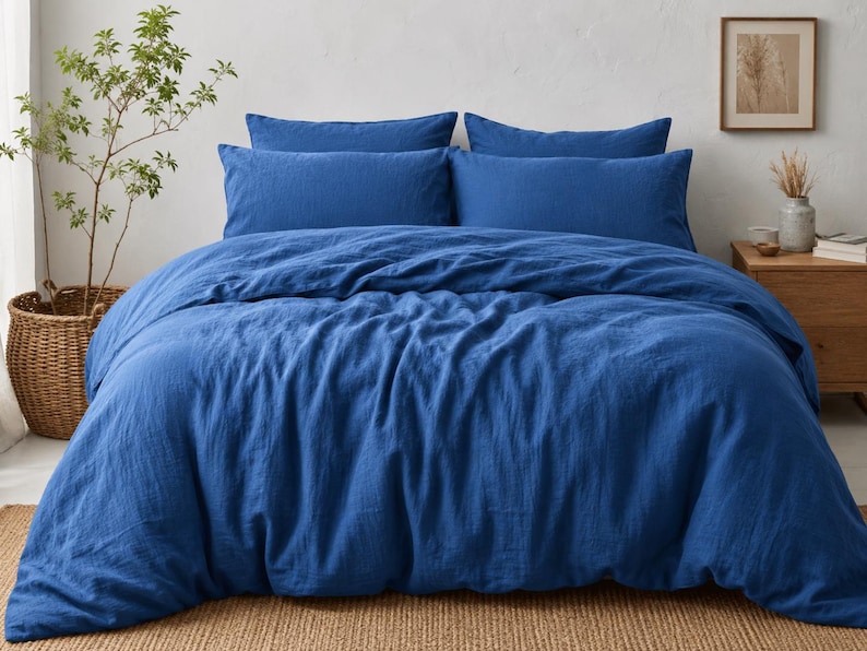 Royal blue linen duvet cover set styled on a modern bed with matching pillow covers in a cozy minimalist bedroom