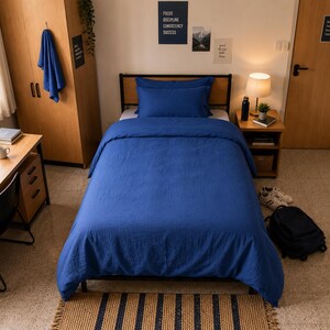 Royal blue linen duvet cover set styled on a modern bed with matching pillow covers in a cozy minimalist bedroom