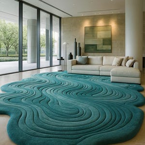 May include: Teal area rug with a flowing, organic design. The rug's pattern resembles water waves, adding a modern touch to the living room. The rug is placed in front of a white sectional sofa and large windows.