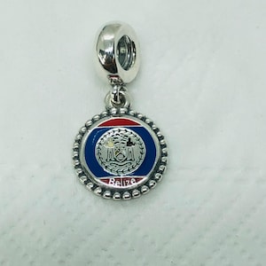 May include: A silver charm with a round pendant featuring the Belize flag design. The pendant has a blue background with a red stripe at the top and the word "Belize" at the bottom. The charm is designed to be added to a bracelet.
