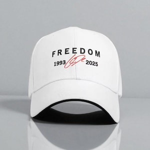 Peut inclure: Casquette de baseball blanche avec le mot "FREEDOM" imprimé en noir, accompagné des années "1993" et "2025". Un graphisme rouge en forme de signature est placé entre les années. La casquette a une visière incurvée.