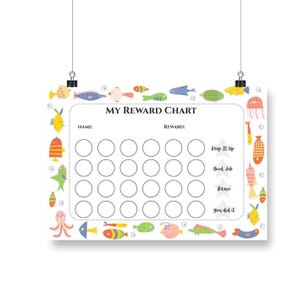 Może przedstawiać: Biały wykres nagród z kolorowymi ilustracjami ryb i napisem "MY REWARD CHART". Wykres ma miejsca na imię, nagrodę i kółka do śledzenia postępów. Zawiera zachęcające zwroty, takie jak "Keep It Up".