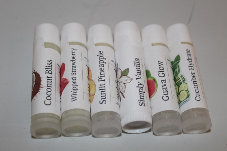 May include: Six white lip balm tubes with labels displaying flavour names and illustrations. Flavours include Coconut Bliss, Whipped Strawberry, Sunlit Pineapple, Simply Vanilla, Guava Glow, and Cucumber Hydrate.