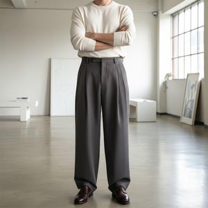 Peut inclure: Une personne portant une chemise cr&egrave;me &agrave; manches longues et un pantalon gris &agrave; plis. Le pantalon a une coupe large et est associ&eacute; &agrave; des chaussures habill&eacute;es en cuir marron. L'ensemble est dans un int&eacute;rieur lumineux et minimaliste.