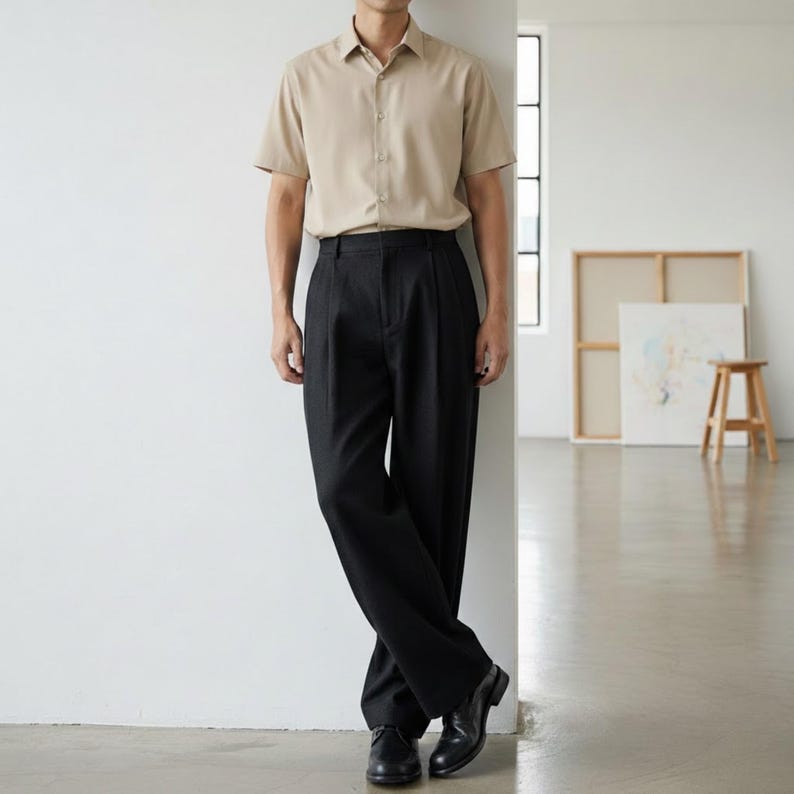 Black pleated dress slacks with wide leg silhouette styled for smart casual office wear