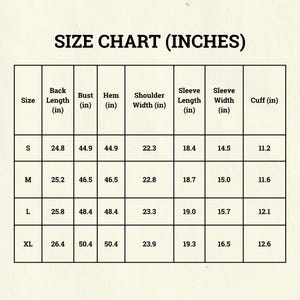 May include: A size chart in inches, with measurements for back length, bust, hem, shoulder width, sleeve length, sleeve width, and cuff. Sizes range from S to XL, with corresponding measurements in inches for each size.