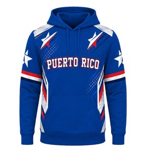 May include: A royal blue hooded sweatshirt featuring the text PUERTO RICO in white block letters across the chest. The design includes white and red star graphics, diagonal stripes, and a front kangaroo pocket with long matching drawstrings.