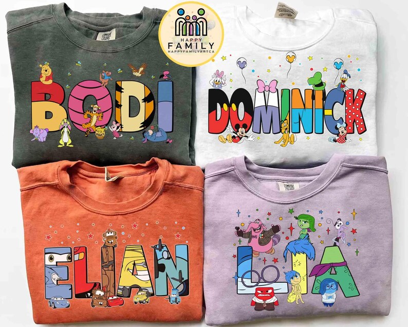 May include: Four crew neck sweatshirts with personalised names and cartoon character designs. The sweatshirts are in green, white, orange, and purple. Each shirt features a different name in colourful block letters with cartoon characters.