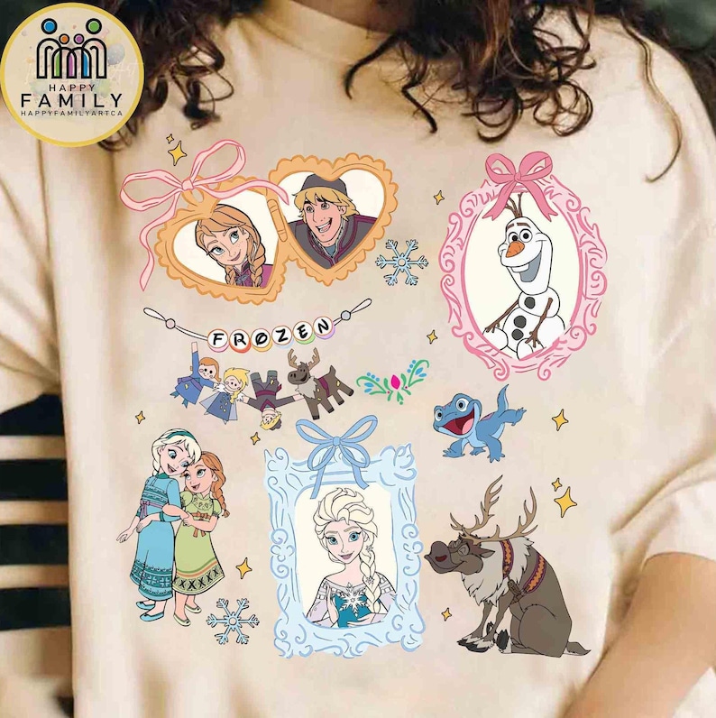 Op de afbeelding: Een beige t-shirt met een grafische print van personages uit Frozen, waaronder Anna, Elsa, Olaf, Sven en Bruni. Het ontwerp bevat hart- en ovaalvormige kaders, een banner met de tekst Frozen en sneeuwvlokaccenten in roze en blauw.