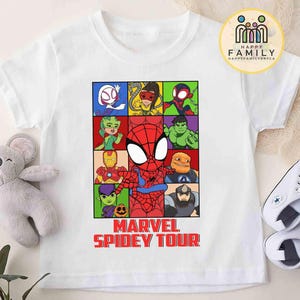 May include: White t-shirt featuring a colorful graphic of Spider-Man and other Marvel characters in a grid. The text "MARVEL SPIDEY TOUR" is printed in red below the grid. A plush koala and white sneakers are next to the shirt.