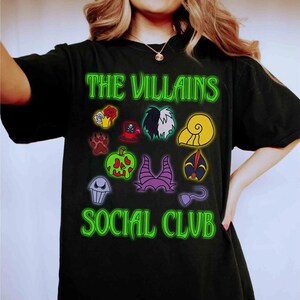 Puede incluir: Camiseta negra con el texto "THE VILLAINS SOCIAL CLUB" en verde ne&oacute;n. La camiseta presenta iconos de dibujos animados coloridos de varios villanos. Una camiseta divertida y elegante para los fan&aacute;ticos de los villanos animados cl&aacute;sicos.