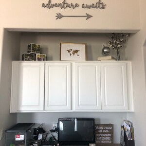 Adventure awaits signs with an arrow. The signs are made of 6mm thick plywood and are painted in Middle grey. They are suitable for wall decor