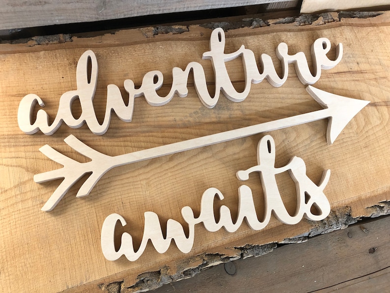 Adventure awaits signs with an arrow in the not painted finish. The signs are made of 6mm thick plywood and are suitable for wall decor.