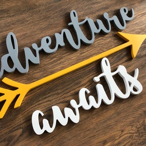 Adventure awaits signs with an arrow. The signs are made of 6mm thick plywood and are suitable for wall decor. Adventure is painted in Middle grey, awaits in white, the arrow - in Mustard yellow