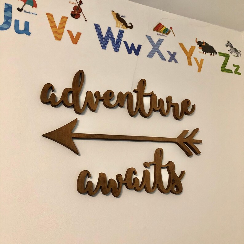 Adventure awaits signs with an arrow. The signs are made of 6mm thick plywood and are painted in Dark wood finish. They are suitable for wall decor.