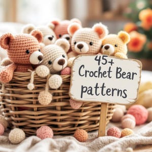 May include: A wicker basket overflowing with several crocheted teddy bears in various shades of brown, cream, and peach. A sign in front reads "45+ Crochet Bear patterns". Scattered around the basket are small yarn balls in matching colors.