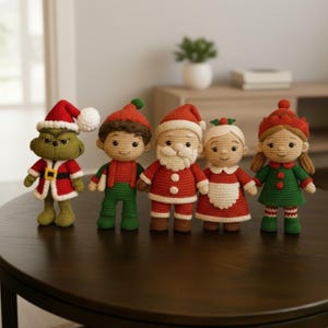 May include: Five handmade crochet Christmas dolls are arranged on a dark brown table. The dolls include a green Grinch, an elf, Santa Claus, Mrs. Claus, and a girl in a green dress. Each doll is wearing a festive outfit with red and green accents.