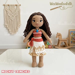 May include: A handmade crochet doll, approximately 14 inches tall, featuring a character with brown hair and a detailed outfit. The doll wears a red and white top, a white skirt with fringe, and a blue necklace. The doll is standing on a white surface.