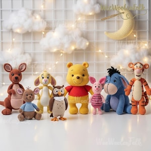 May include: A collection of eight crocheted stuffed animal figures including a brown kangaroo, a small brown joey, a yellow rabbit, a brown owl, a yellow bear in a red shirt, a small pink pig, a blue donkey, and an orange striped tiger.