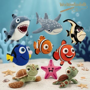 May include: A collection of crocheted sea creatures including a grey shark, a spotted whale shark, a black and white angelfish, a blue tang, two orange clownfish, a pink starfish, and two green sea turtles with brown shells.