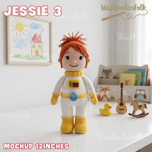Puede incluir: Mu&ntilde;eca de ganchillo hecha a mano llamada Jessie 3, con un traje de astronauta blanco y amarillo. La mu&ntilde;eca tiene pelo naranja y mide aproximadamente 30 cm de altura. La imagen incluye un dibujo infantil y otros juguetes.