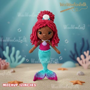 Op de afbeelding: Gehaakte zeemeerminpop met rood haar, een roze top en een turquoise staart. De pop heeft een parelketting en een schelp haaraccessoire. De tekst "MOCKUP 12INCHES" staat onderaan. De pop is ongeveer 30 cm hoog. Onderwaterachtergrond.