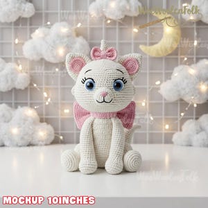 May include: A white crocheted cat plush toy with large blue eyes, long eyelashes, and a pink nose. The cat features a pink bow on its head and a larger pink bow around its neck. The text at the bottom reads MOCKUP 10INCHES.