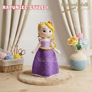 May include: A handmade crochet doll in the style of Rapunzel, wearing a purple dress with a yellow belt and bodice. The doll has blonde hair and a floral crown. The text "RAPUNZEL STYLE 1" is at the top.