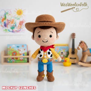 May include: A crocheted doll resembling a cowboy character, approximately 12 inches tall. The doll wears a brown hat, a yellow shirt with a black and white vest, blue jeans, a red bandana, and brown boots. The doll has a smiling face.