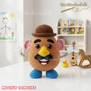 May include: A crocheted Mr. Potato Head doll, approximately 14 inches tall, with a brown body, hat, and mustache, a yellow nose, pink ears, and blue shoes. The doll has white hands and a smiling mouth. The doll is a handmade toy.