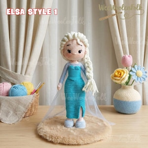May include: A handmade crochet doll in the style of Elsa from Frozen, with a long white braid and a turquoise dress. The doll is standing on a small, round, brown rug. The text "ELSA STYLE 1" is in the upper left corner.
