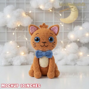 May include: A 10-inch tall crocheted orange cat toy featuring large blue eyes, pink inner ears, a cream-colored belly patch, and a blue bow tie. The cat is crafted with detailed yarn stitching and has a small tuft of hair on top of its head.