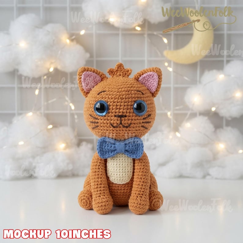 May include: A 10-inch tall crocheted orange cat toy featuring large blue eyes, pink inner ears, a cream-colored belly patch, and a blue bow tie. The cat is crafted with detailed yarn stitching and has a small tuft of hair on top of its head.