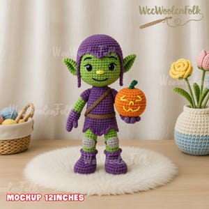 May include: A handmade crochet goblin doll, approximately 12 inches tall, in shades of green and purple. The doll is holding a carved orange pumpkin. The doll has a smiling face and is wearing a purple outfit with green accents. The text "Mockup 12 inches" is at the bottom.