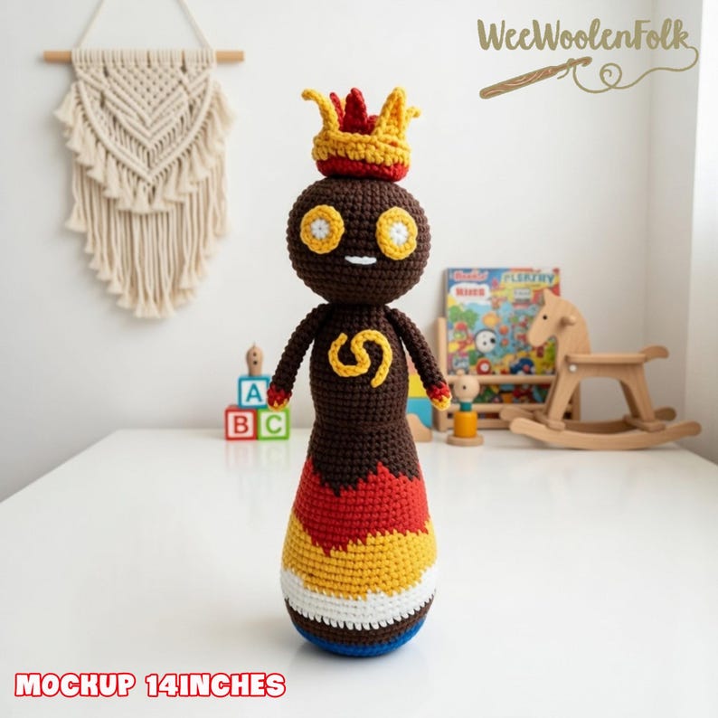 May include: A handmade crochet doll, approximately 14 inches tall, featuring a brown body, a yellow crown, and a colorful skirt. The doll has yellow eyes and a yellow 'S' on its chest. The base of the doll is white, blue, and yellow.