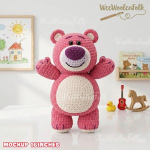 May include: A handmade pink crochet bear with a white belly and purple nose. The bear is approximately 16 inches tall. The bear has a smiling face and outstretched arms. The text "MOCKUP 16 INCHES" is at the bottom of the image.