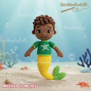Op de afbeelding: Een gehaakte zeemeermindoll met bruine huid, haar en armen. De pop draagt een groen shirt met een wit schildpadontwerp en een gele en groene staart. De tekst "MOCKUP 12INCHES" staat onderaan.