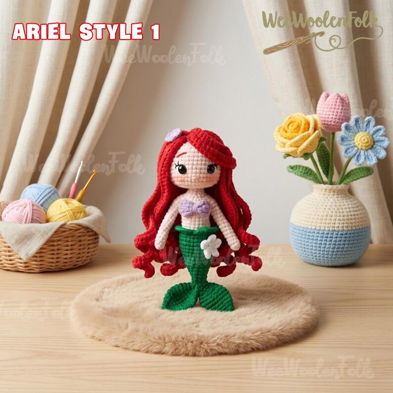 May include: Ariel Style 1 crochet doll with red hair, a purple top, and a green tail. The doll is displayed on a brown surface. A woven basket with yarn and a crochet hook is in the background. The text "We Woolen Folk" is visible.